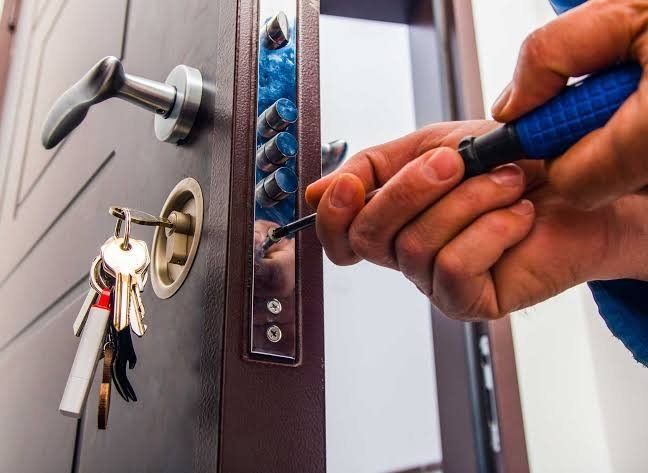 Cerrajero abriendo la cerradura de una puerta de departamento sin romperla